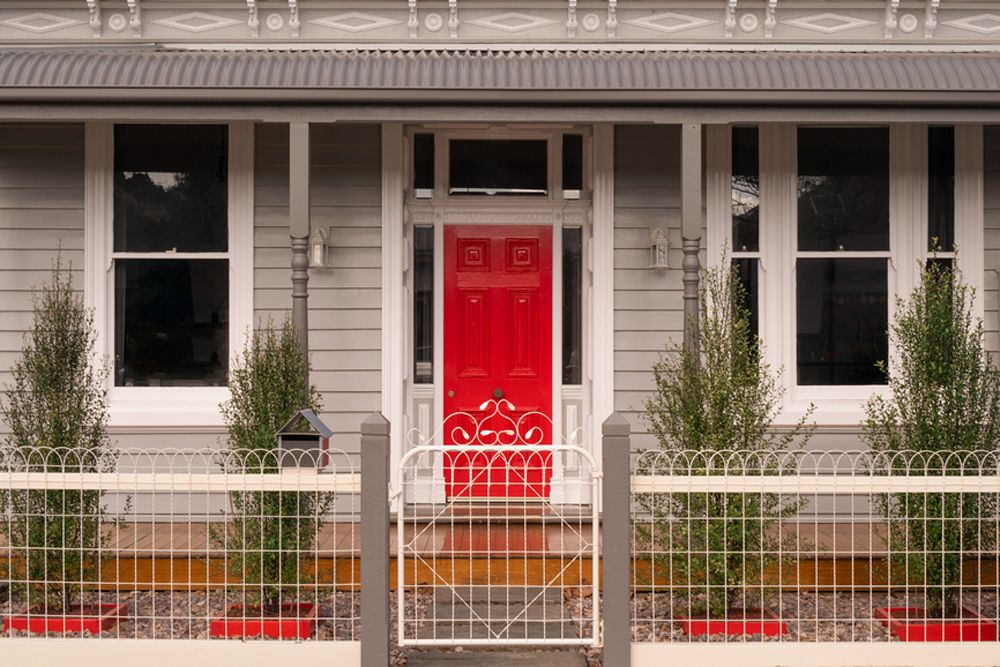 منزل رمادي داكن مع باب أحمر