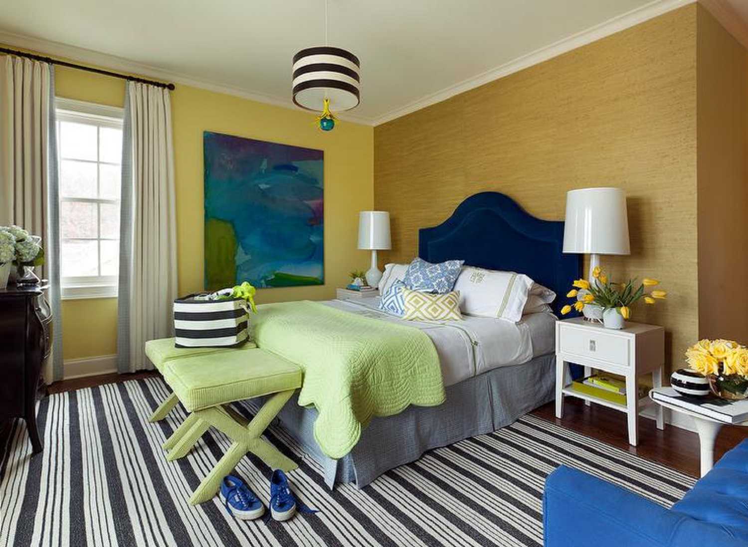 غرفة نوم ذهبية وزرقاء مع سجادة مخططة.