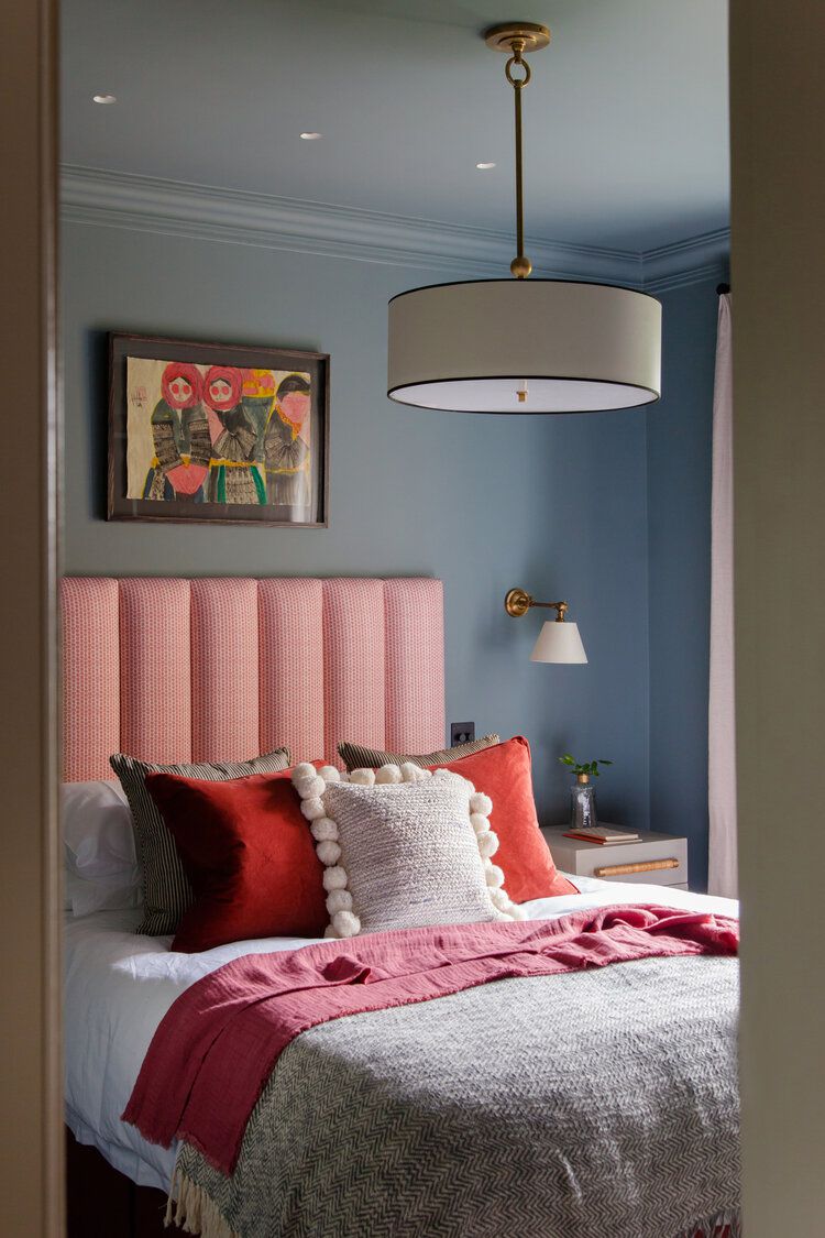 غرفة نوم في سن المراهقة بجدران زرقاء مغبرة ولهجات سرير باللونين الوردي والأحمر.