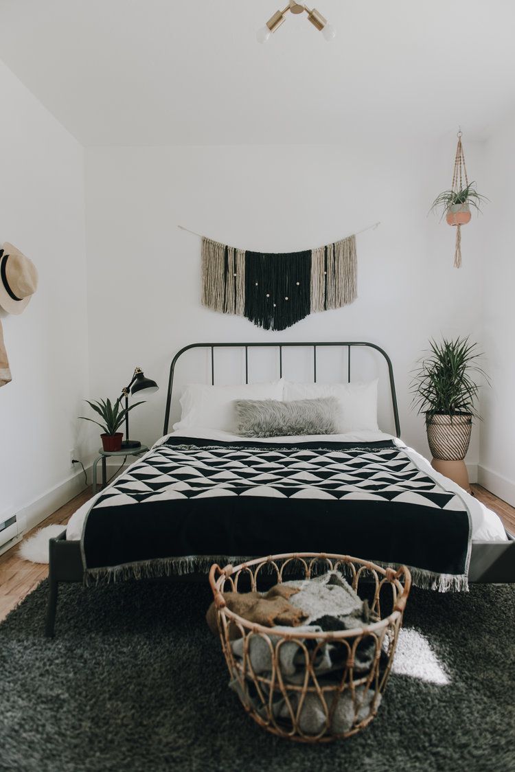 غرفة نوم مع لمسات باللونين الأسود والأبيض ، بما في ذلك بطانية رمي على السرير.