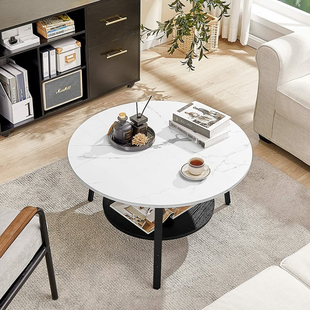 طاولة قهوة دائرية حديثة في غرفة المعيشة ذات سطح رخامي أبيض و ورف أسود سفلي
