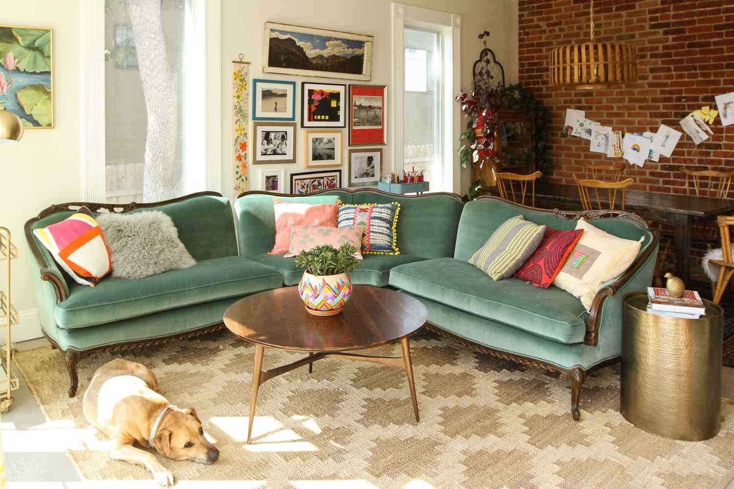 أريكة عتيقة باللون الأزرق المخضر مغطاة بوسائد منقوشة في غرفة المعيشة